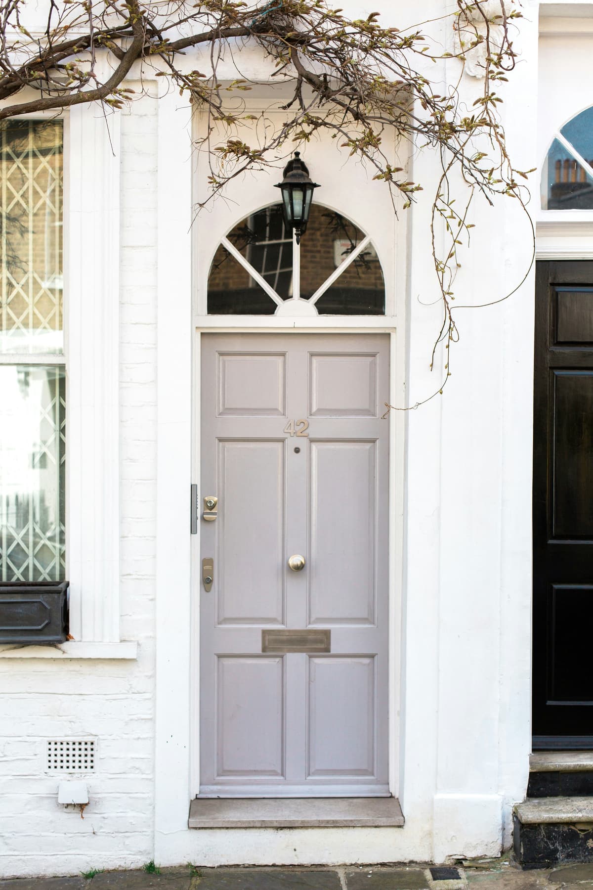 Period front door with arched fanlight freshly painted in pale grey